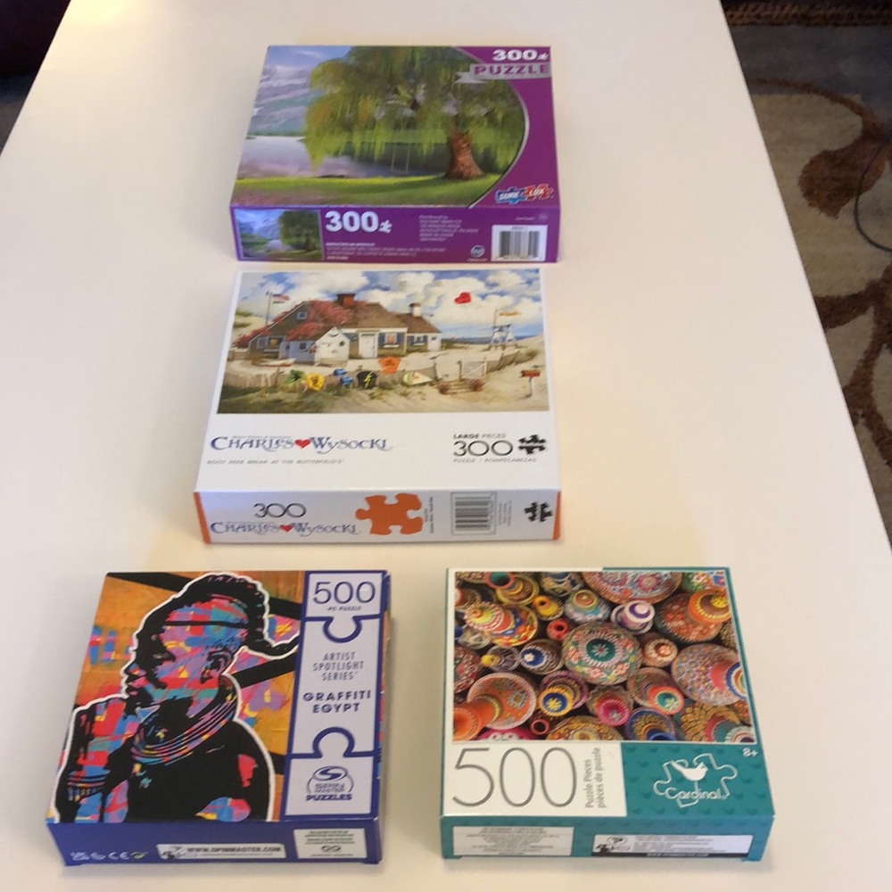 Bundle of four puzzles: no missing pieces, original packaging, one never opened.
